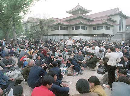 Des centaines de Chinois manifestent silencieusement le long de l'avenue Chang'an, à côté de l'enceinte des dirigeants de Zhongnanhai de Beijing, le dimanche 25 avril 1999. Des milliers de personnes ont rempli la rue pour exiger le droit de pratiquer un système de méditation connu sous le nom de Falun Gong. Il s'agit de la plus grande manifestation jamais organisée dans la capitale chinoise depuis le massacre de Tian An Men.