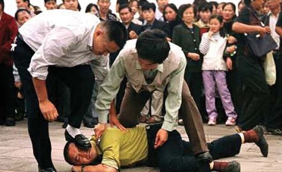 La police arrête un manifestant du Falun Gong sur la place Tiananmen le 1er octobre 2000.