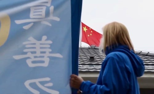 Une pratiquante de Falun Gong tenant une banderole devant l'ambassade de Chine à Belgrade (minghui.org, 2019) 